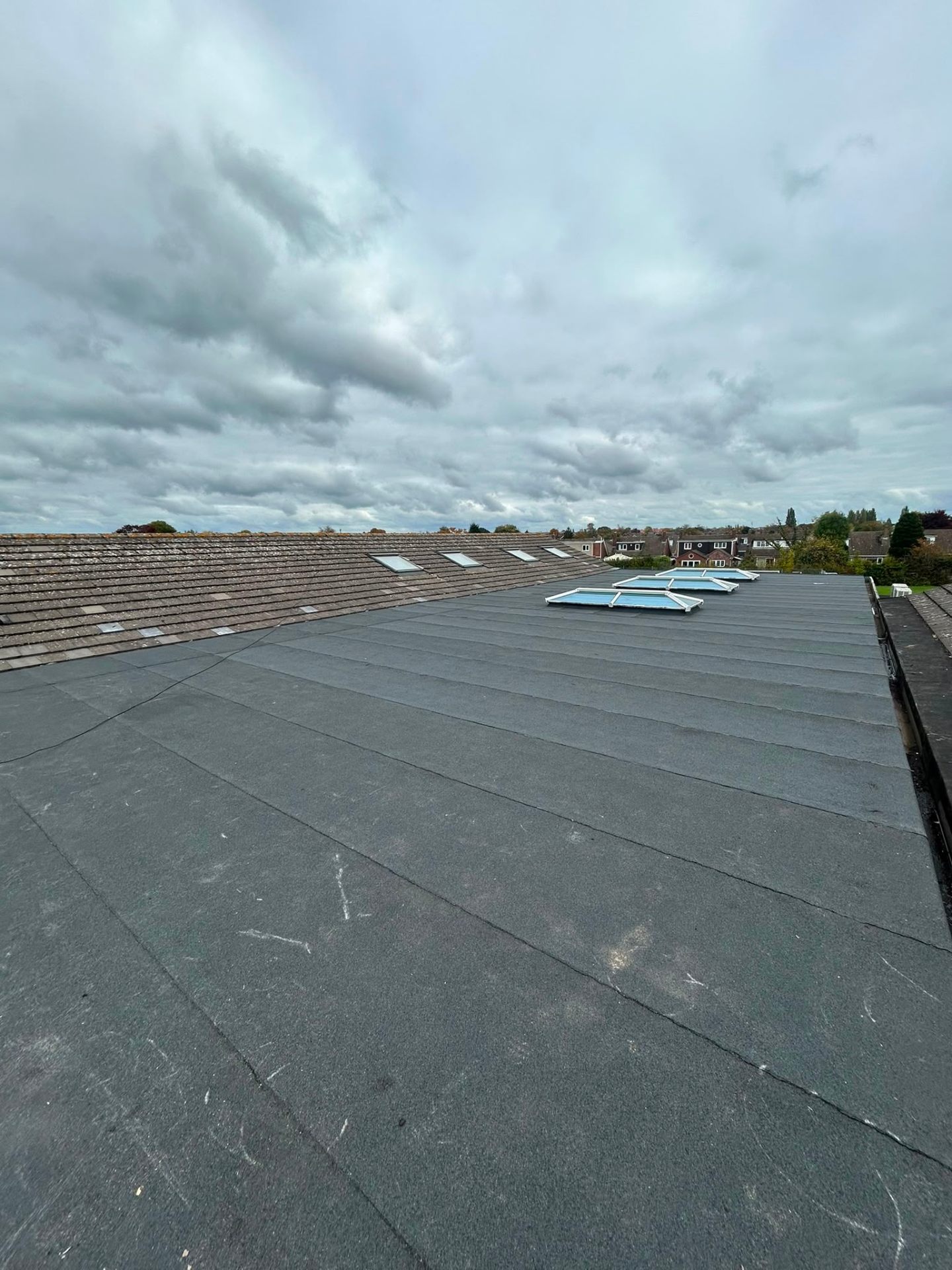 Finished dark grey flat roof with rooflights and lanterns
