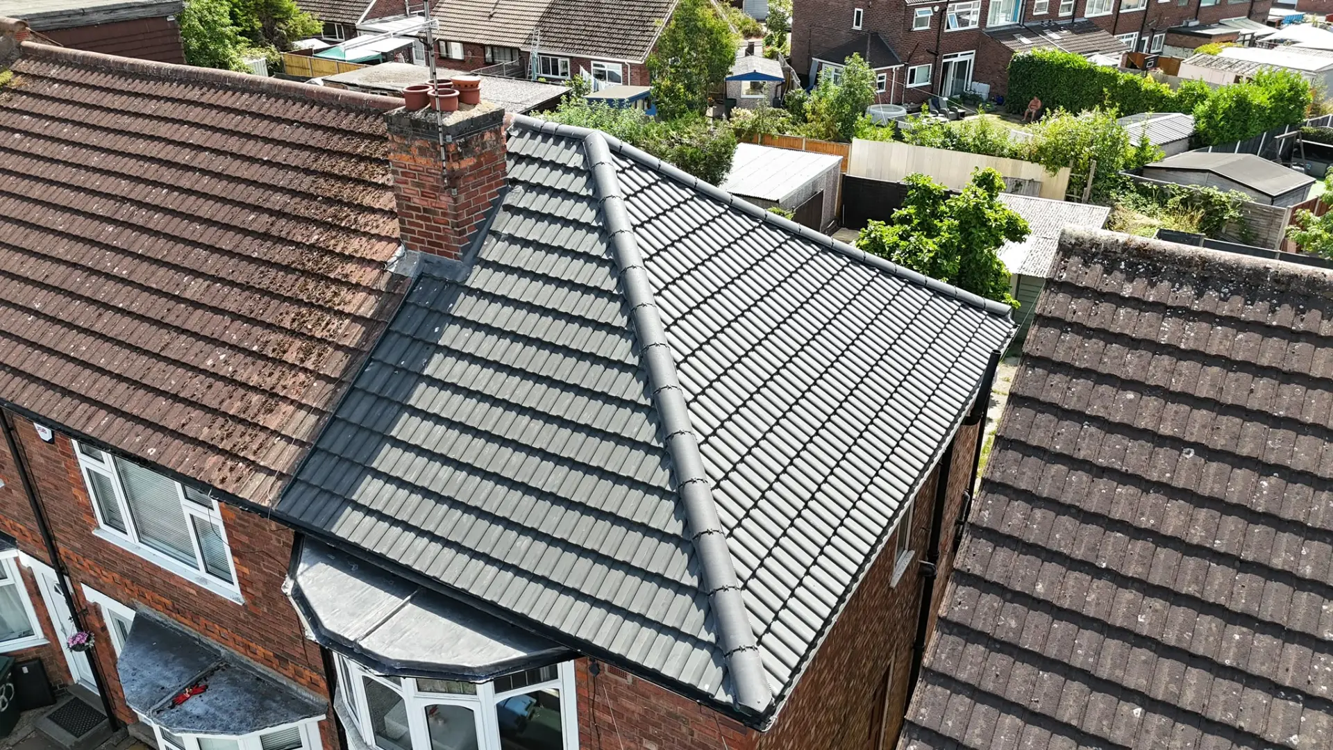 Completed grey tiled re-roof with new ridge and lead work