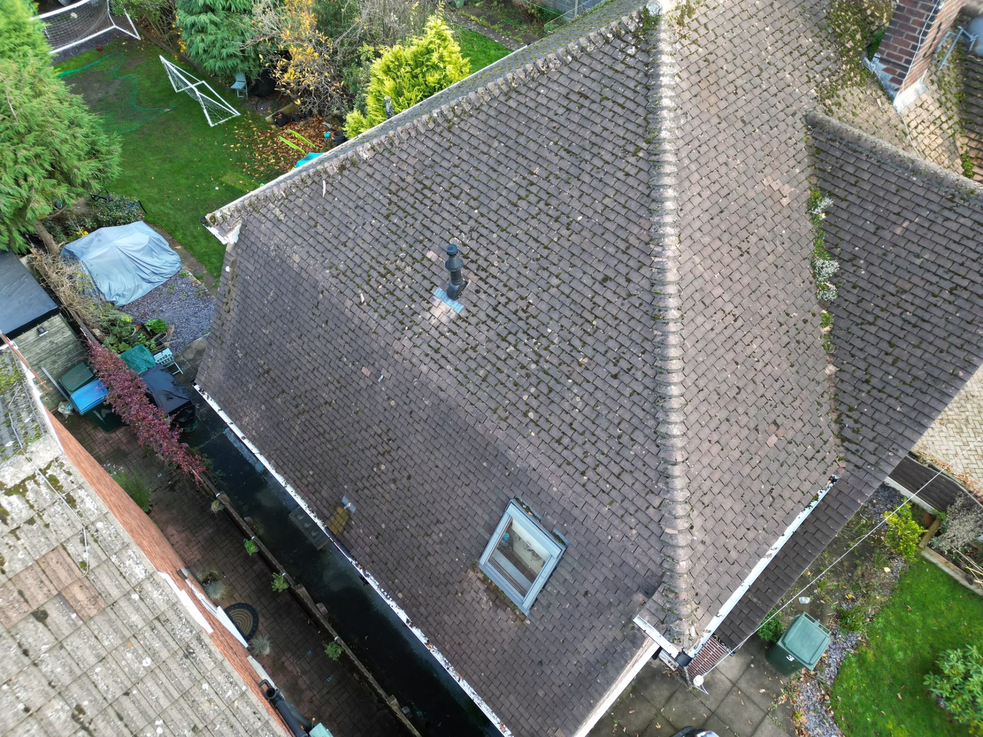 Weathered mossy dark tiled roof before emergency repair by Morgan Roofing