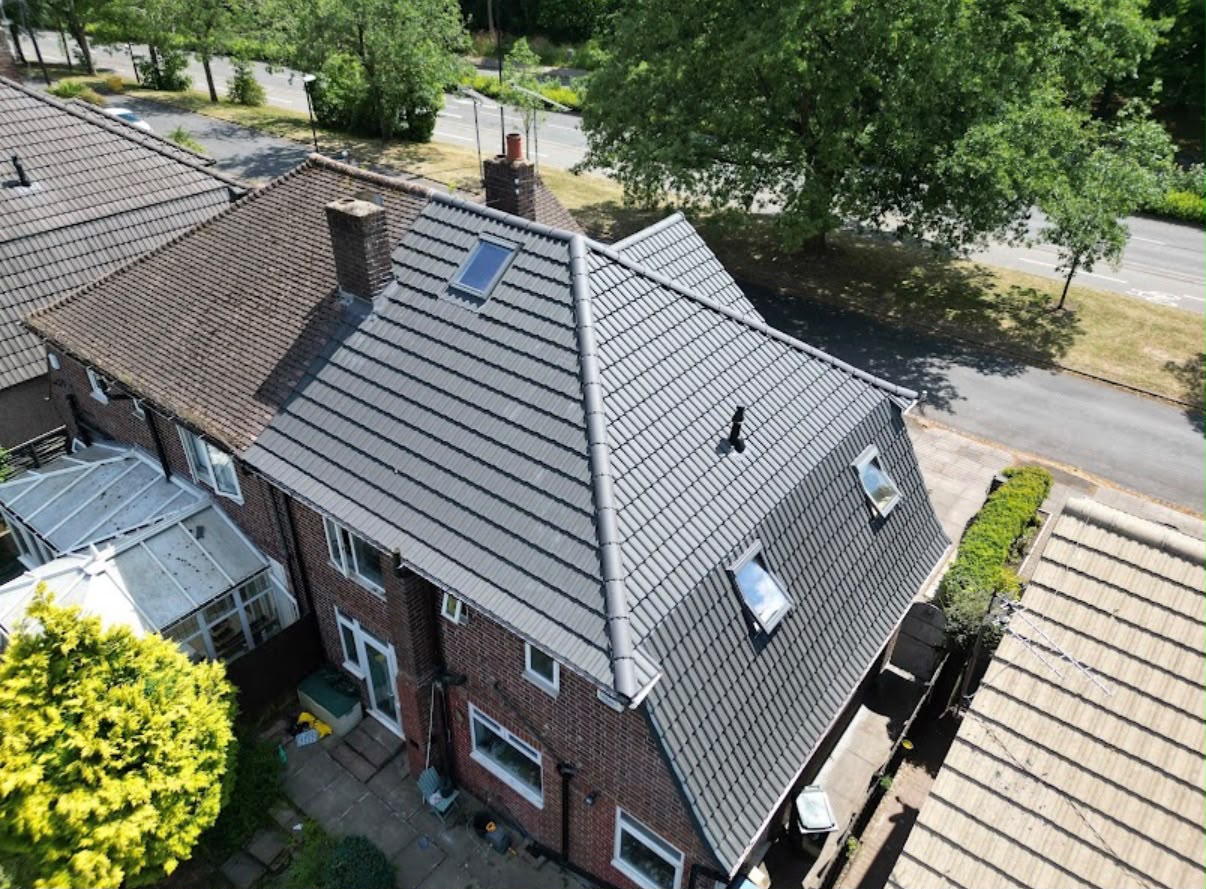 Top-down view of newly installed grey tiled pitched roof with rooflights, Warwickshire